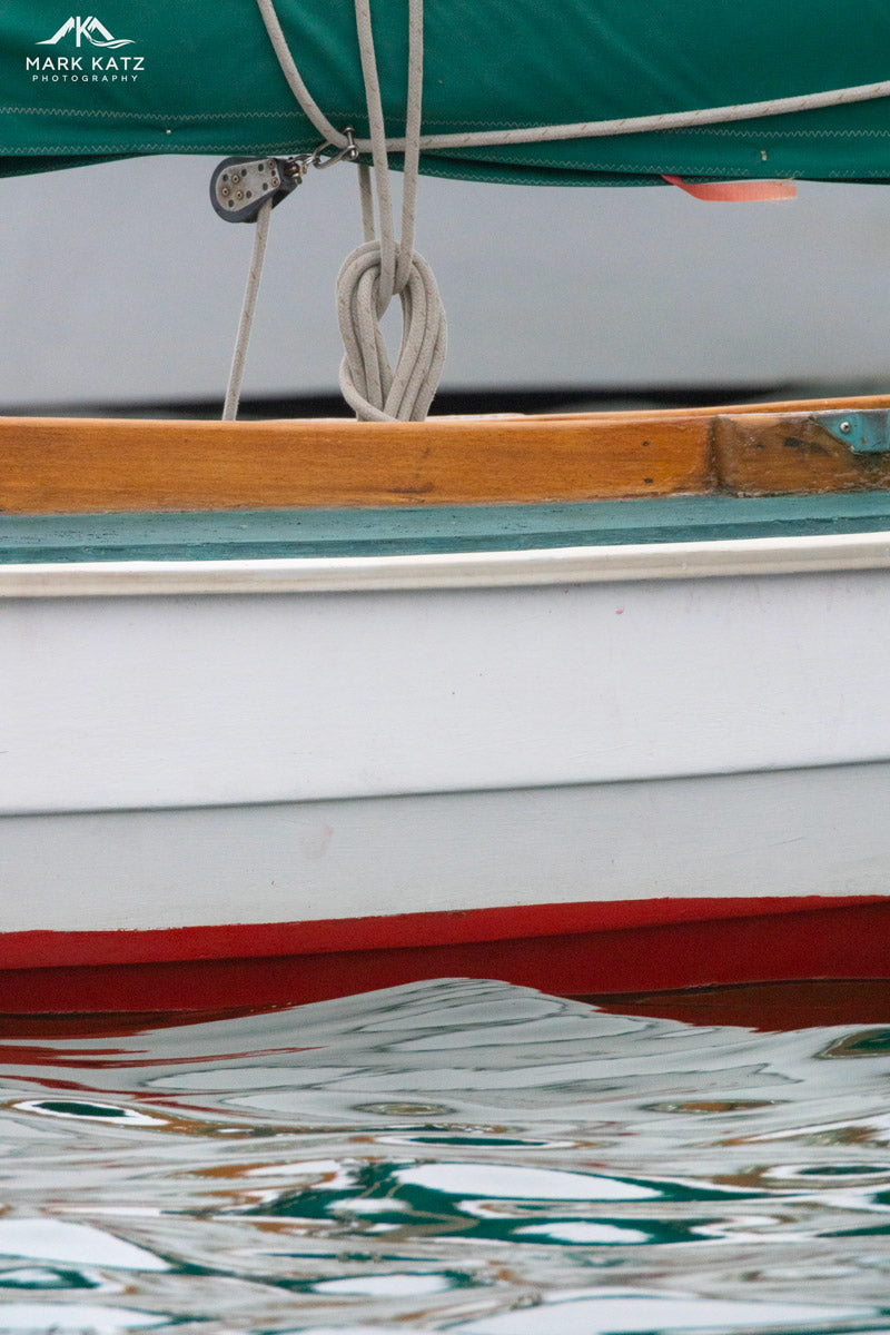 Calm ocean waters reflecting sailboat hues, serene fine art photography print.