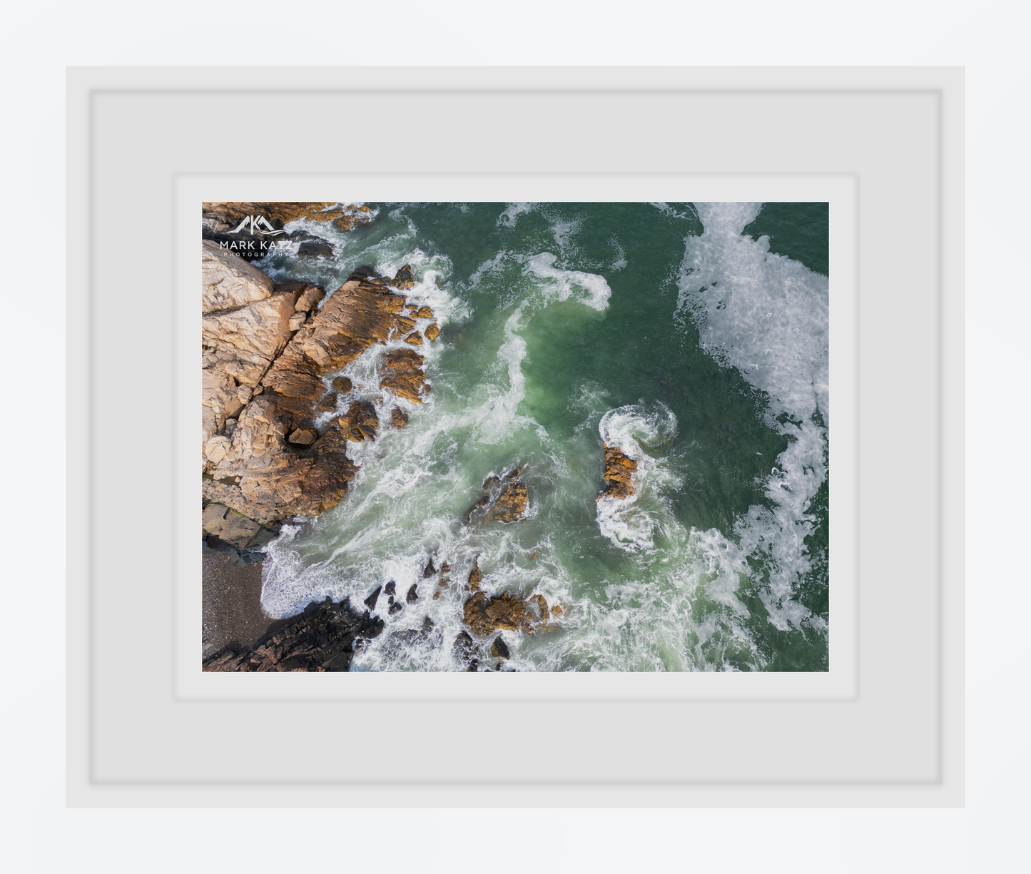 Framed artwork of ocean waves crashing against rocks