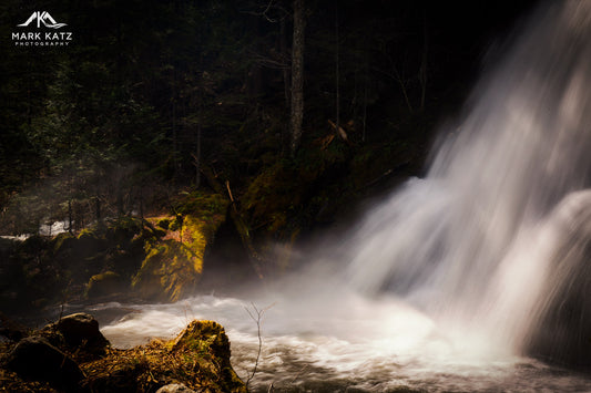 Water cascading over rocks in dramatic waterfall scene, fine art photography titled “Movement.”