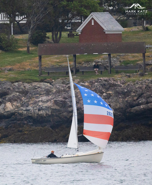 American flag themed sailboat returning to harbor, nautical fine art photography for coastal walls.