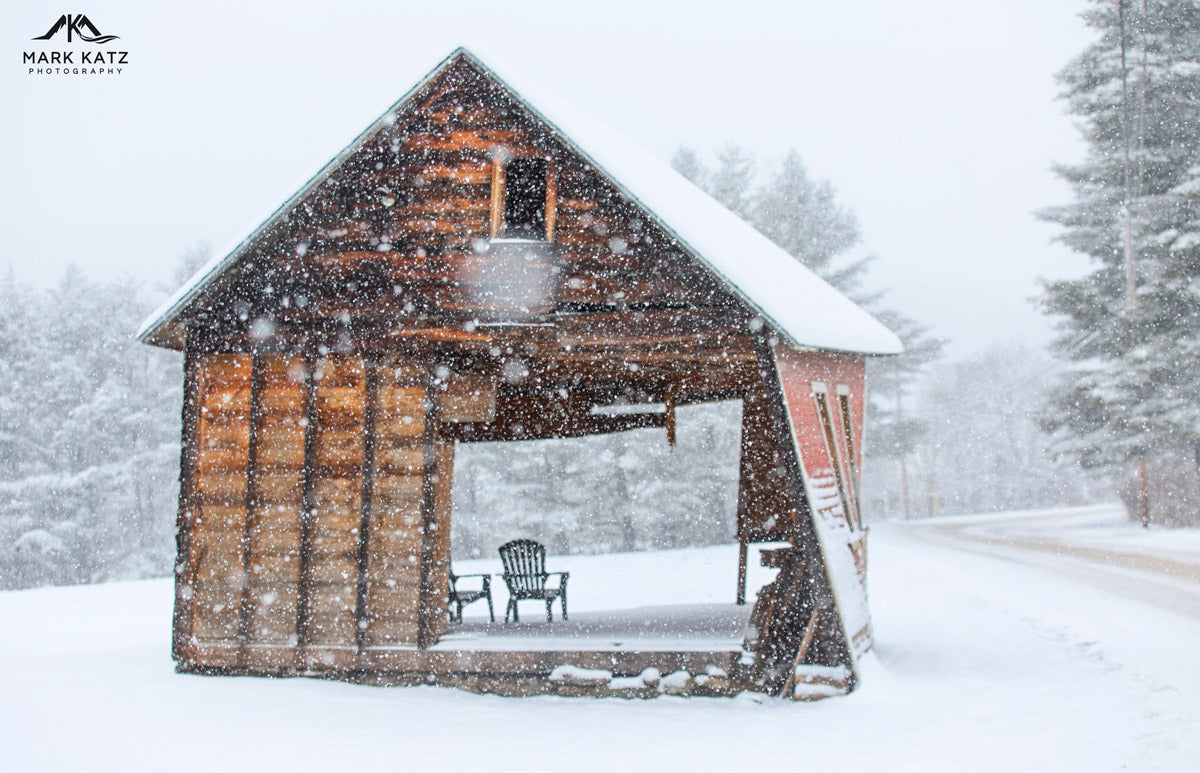 Old red barn, evoking cozy rustic snowglobe in fine art winter photography.