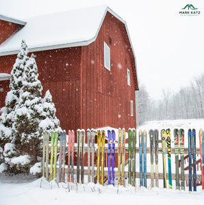 Red Vermont barn amidst snowy hills, nostalgic fine art winter photography evoking skiing adventures.