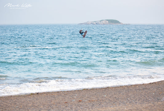 Windsurfer airborne above turquoise water, energetic coastal sports fine art photography print.