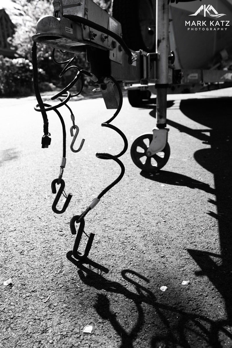 Abstract black and white ropes dangling from boat, minimalist maritime fine art photography piece.