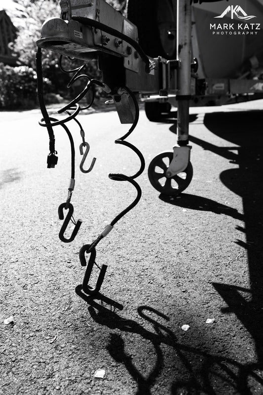 Abstract black and white ropes dangling from boat, minimalist maritime fine art photography piece.