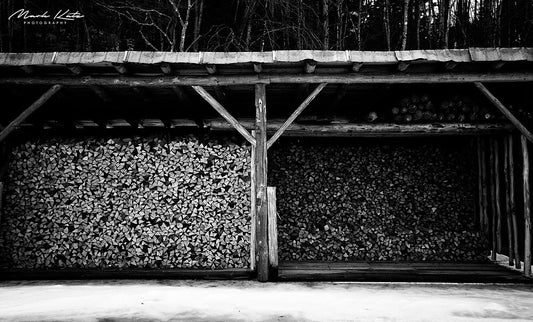 Pile of chopped wood stacked in geometric black and white pattern, by Mark Katz Photography. 