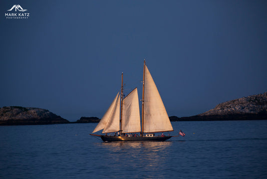 Elegant schooner under dramatic skies, gallantly streaming across ocean in fine art nautical photograph.