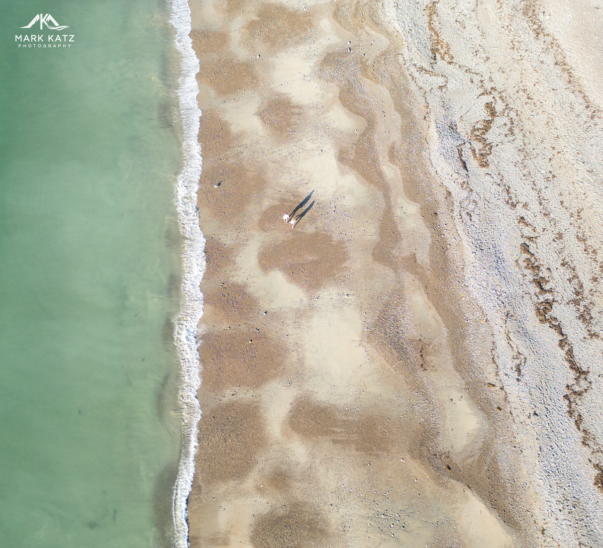 Aerial view of Devereux Beach with shoreline, sand, and green water