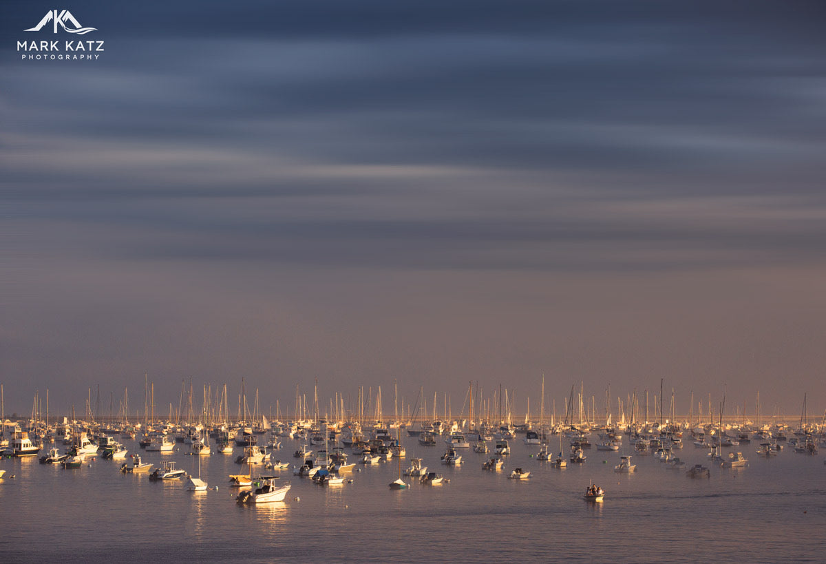 Evening harbor lights reflecting across water, beautiful coastal fine art photography for wall decor.