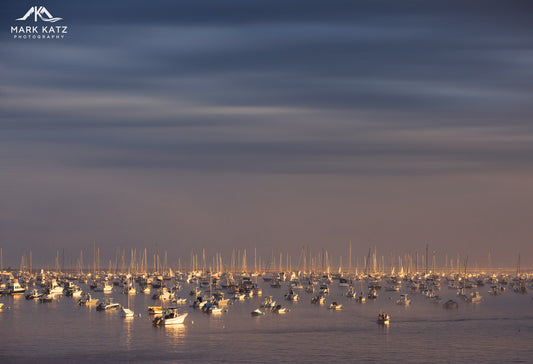 Evening harbor lights reflecting across water, beautiful coastal fine art photography for wall decor.