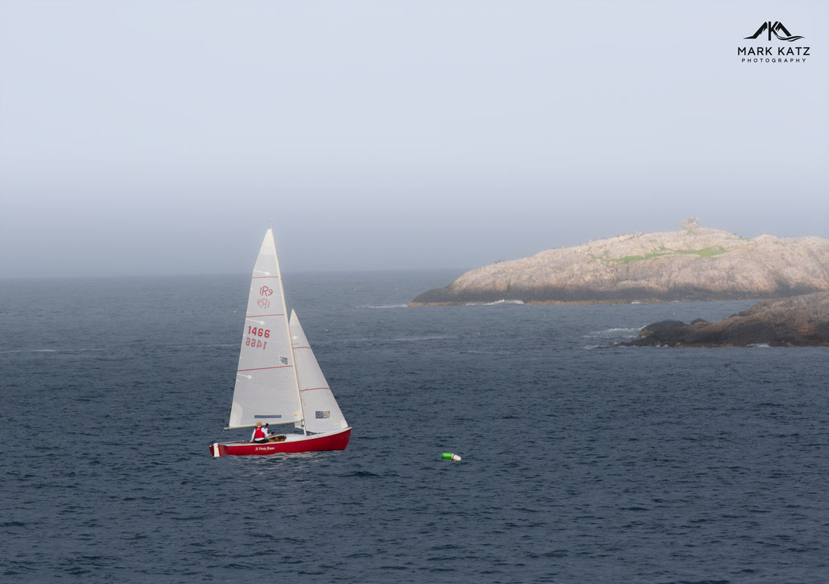 Single red sailboat standing out on blue ocean, minimalistic fine art photography for maritime lovers.