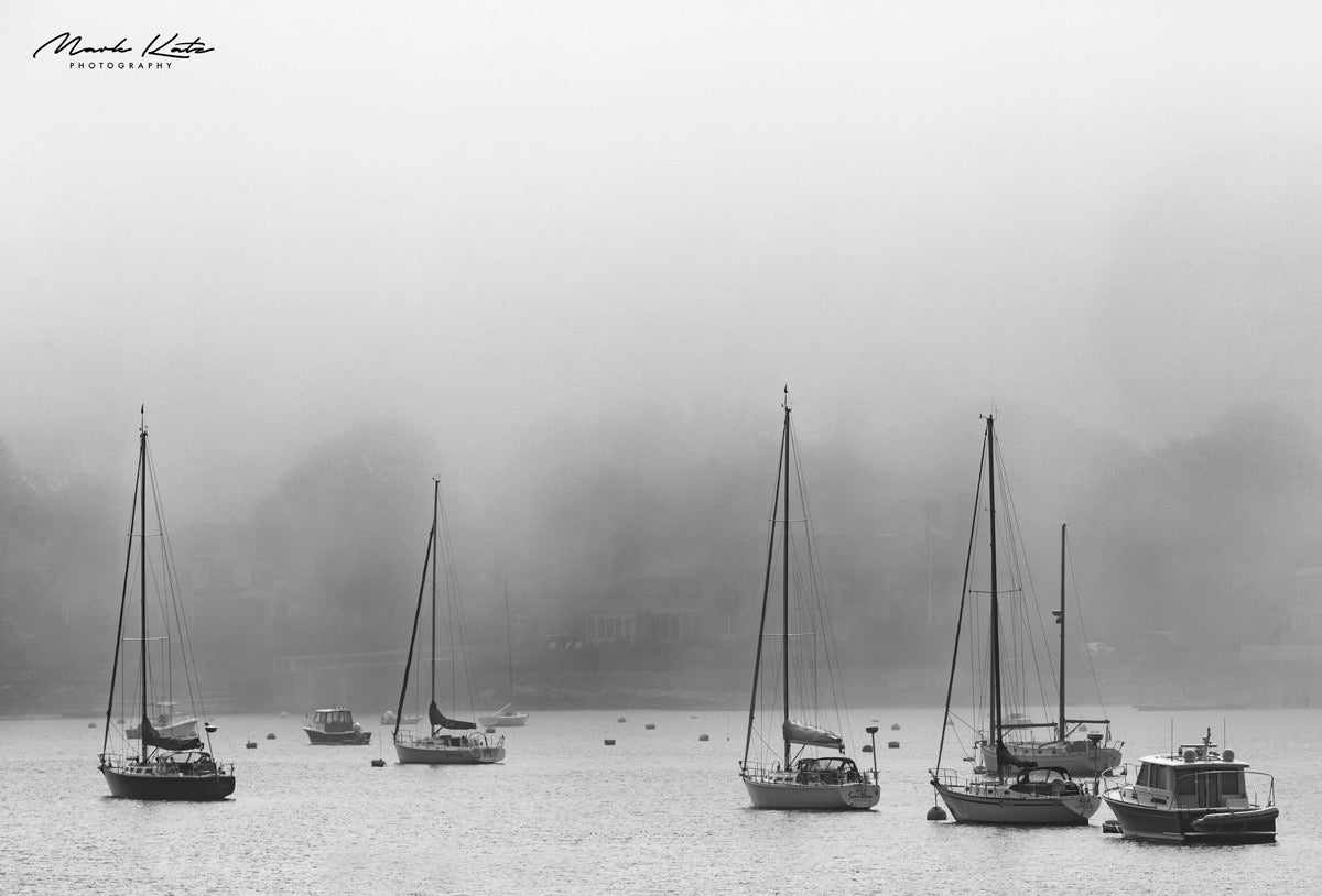 Sailboats forming geometric shapes in foggy harbor, minimalist nautical fine art photography.