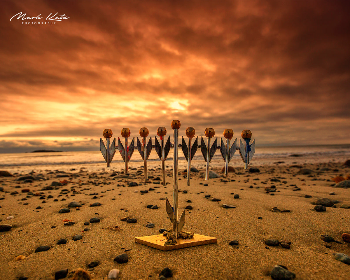 Coastal scene featuring festive menorah on beach, unique coastal Chanukah fine art photography.