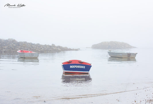 Single boat anchored on snowy harbor, symbolizing independence in nautical winter fine art photography.