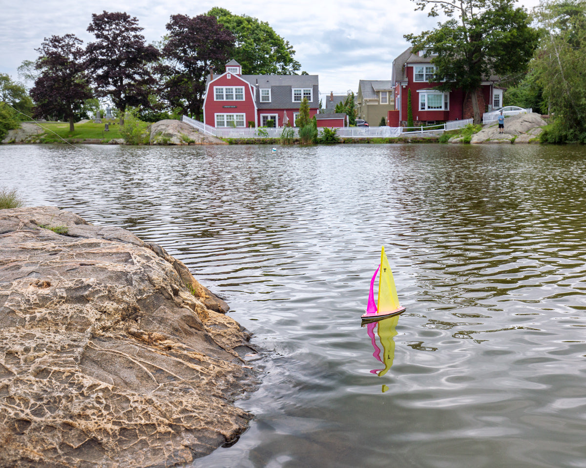 Small sailboat floating on calm Redd’s Pond, peaceful fine art coastal photography for serene decor.