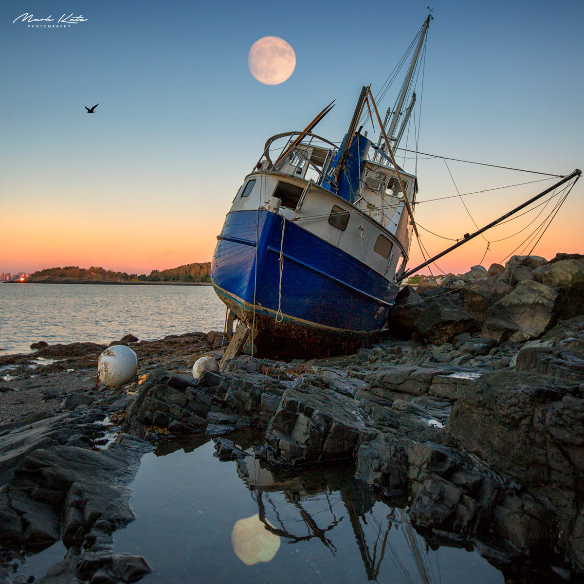 Dramatic shipwreck on rocky shore, nautical fine art photography capturing the story of shipwrecked vessels.