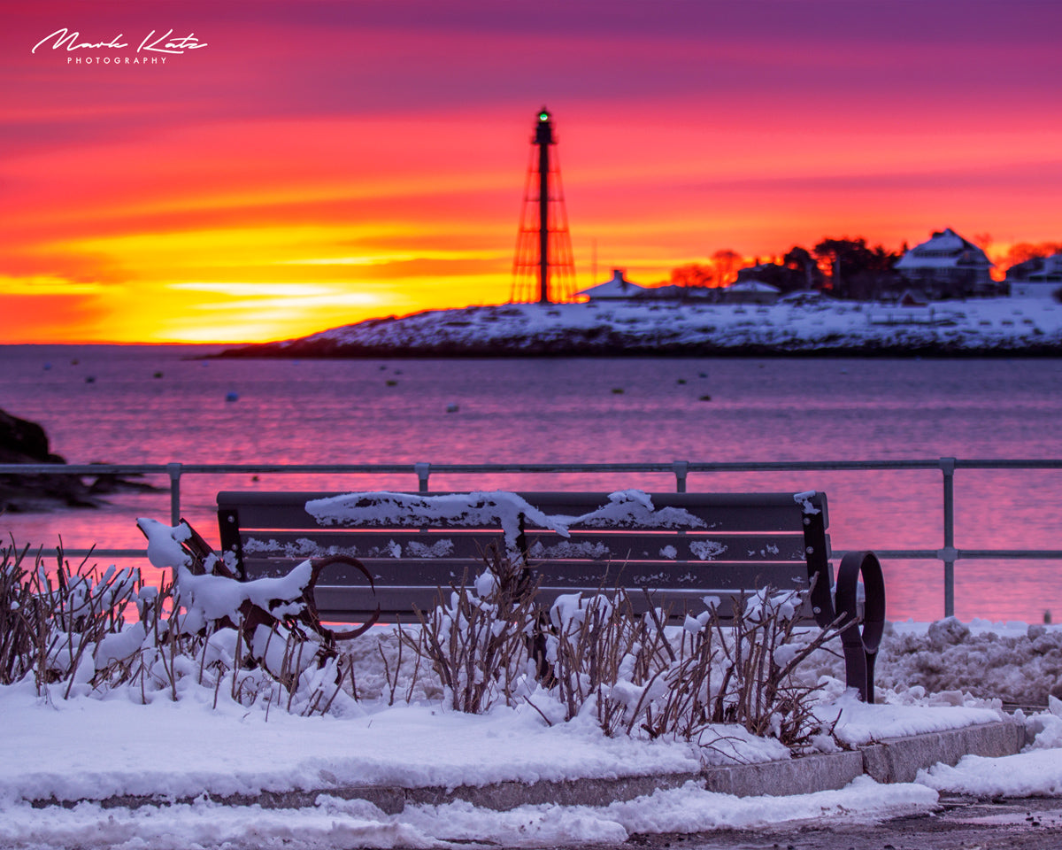 Snowy harbor glowing under pink and orange winter sunrise, peaceful seasonal nautical fine art photo.